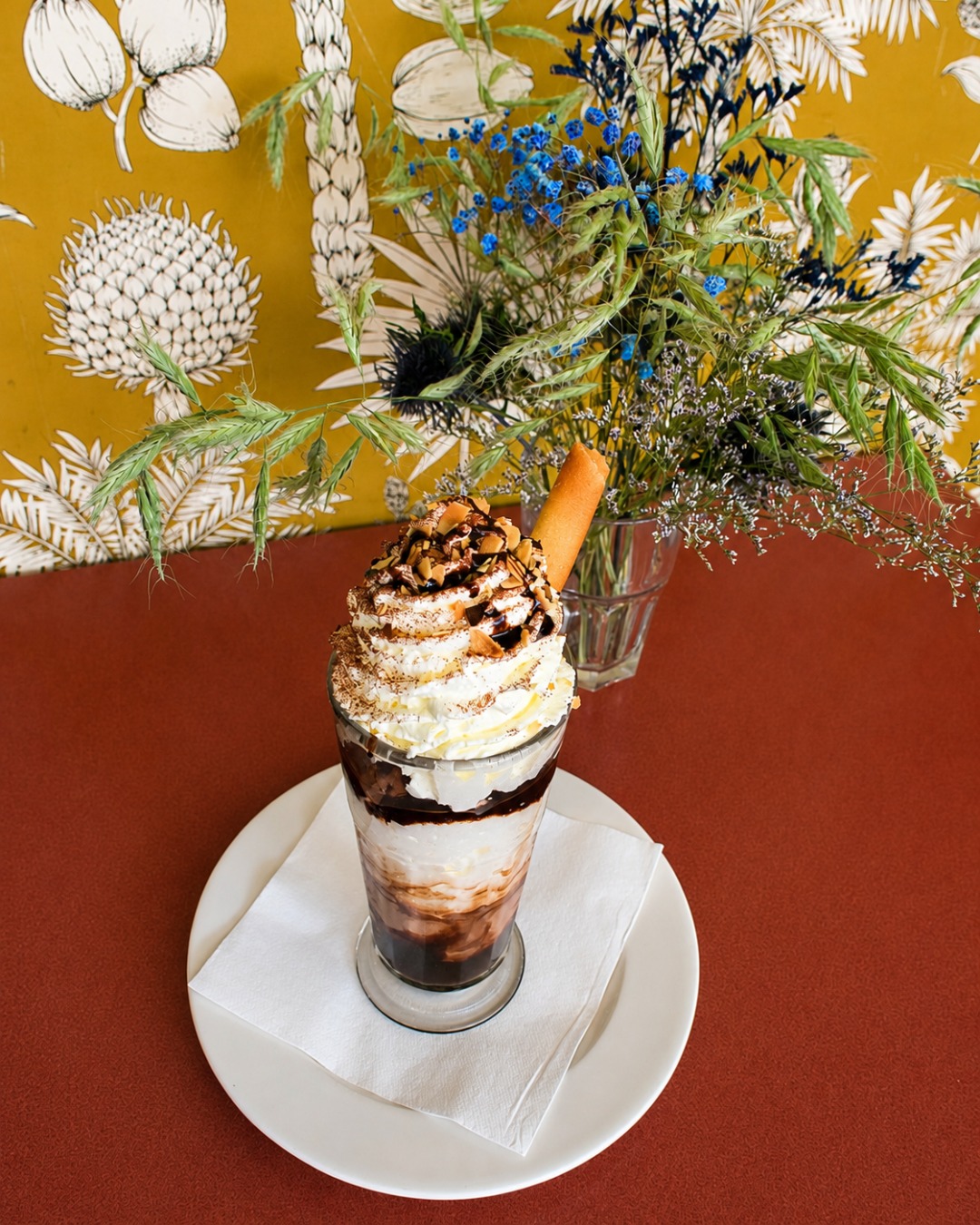 Dessert glacé au chocolat devant le papier peint botanique
