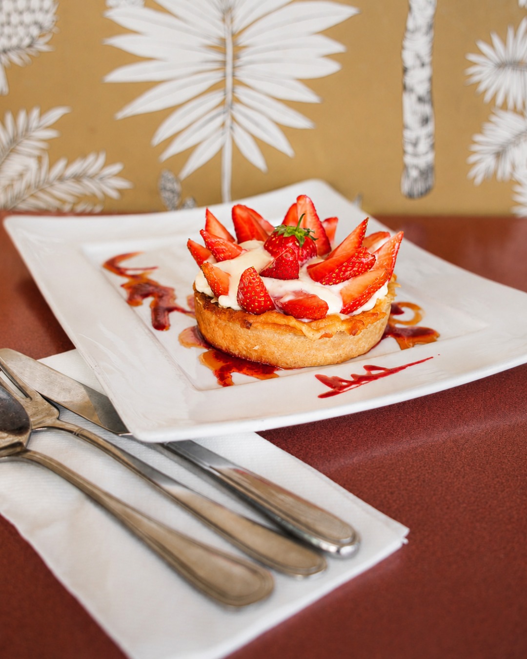 Tarte aux fraises et crème servie sur une assiette blanche